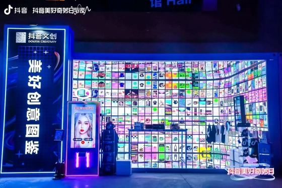 抖音文创 DOUYIN CREATIVITY (lightbox tower); 美好创意图鉴; 抖音 logo on merchandise bags; overlay 抖音 / 抖音美好奇妙日 booth — 抖音美好奇妙日