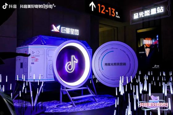 抖音 logo mark (backlit porthole); 巨量星图 sign; ♪抖音 on vertical screen; 星光能量站; 12-13馆 Halls booth — 抖音美好奇妙日