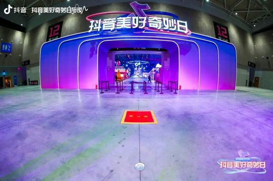 抖音 (抖音美好奇妙日 fascia lettering + Douyin note mark on the arch); 抖音 / Kilala 可啦啦 (overlay watermarks) booth — 抖音美好奇妙日