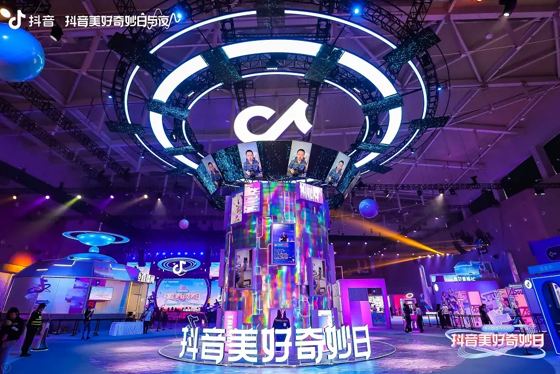 Douyin note mark (giant suspended ring lightbox); 抖音 (抖音美好奇妙日 ground lettering and stage screen); 抖音 / Kilala 可啦啦 (overlay watermarks) booth — 抖音美好奇妙日